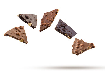 Milk and dark pieces of hazelnut chocolate flying on white background.