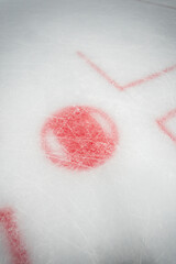 Red circle on ice marking close up - face off spot on hockey rink