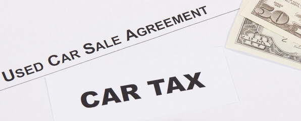 Inscription car tax, dollar banknotes and vehicle sales agreement. Sales, purchases, taxation of automobile
