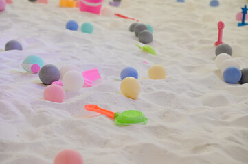 BANGKOK, THAILAND - JULY 1, 2024: Closeup of Colorful Plastic Children's Toy Set laying on dry sand playground on yard in the park at Thailand.