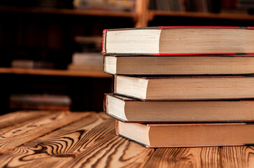 Old books stacked against the background of bookshelves