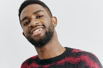 Obraz premium Confident young man in red sweater smiling against minimalist white background