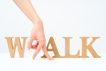 「WALK」と並べられたアルファベットの木製ブロック
