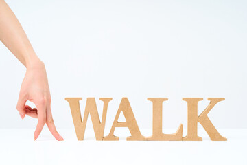 「WALK」と並べられたアルファベットの木製ブロック