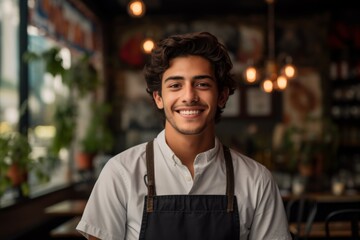Smiling portrait of a young waiter in the restaurant