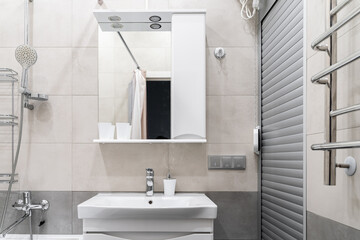 modern bathroom design with light-colored tiles, white furniture and a white toilet bowl. Bathroom mirror