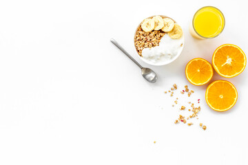 granola with banana slices and orange juice for breakfast on blue background top view copyspace