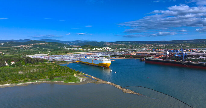 AERIAL: White and yellow freight ship loading cars from Koper port parking lot.