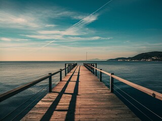 Fototapeta premium A wooden dock extending out into a calm lake on a sunny day.