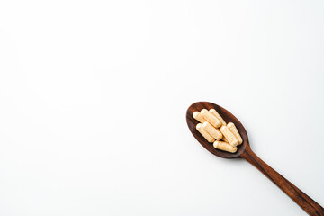 Herbal capsules in wooden spoon, Natural herbs, Alternative Medicine, Herbal supplement