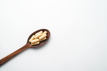 Herbal capsules in wooden spoon, Natural herbs, Alternative Medicine, Herbal supplement