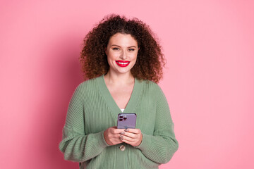 Photo of cheerful cute woman wear trendy khaki clothes hold apple iphone isolated on pink color...