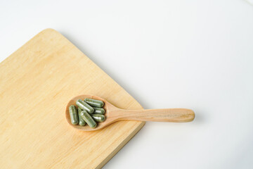 Herbal capsules in wooden spoon, Natural herbs, Alternative Medicine, Herbal supplement