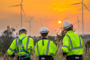 Team Engineers men and woman checking and inspecting on construction with sunset sky. people operation. Wind turbine for electrical of clean energy and environment. Industrial of sustainable.