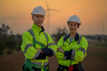 Team Engineers men and woman checking and inspecting on construction with sunset sky. people operation. Wind turbine for electrical of clean energy and environment. Industrial of sustainable.