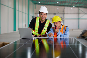 workers or technicians working on laptop computer and checking solar panel in the factory