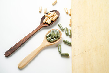 Herbal capsules in wooden spoon, Natural herbs, Alternative Medicine, Herbal supplement