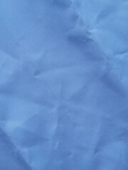 A blue piece of fabric. Raincoat fabric, lining fabric. Wrinkled fabric. Cloth. Background, texture. Sewing.