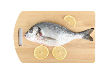 Lemon slices and peeled and poached dorada fish on a wooden cutting board.