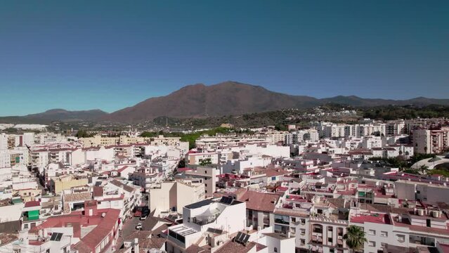 Panoramic coastal city view with mountains, urban architecture, rooftops, and clear sky