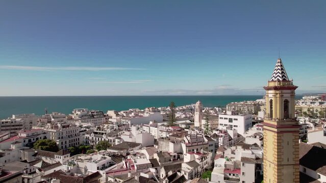 Aerial view of a coastal city with rooftops, buildings, and a picturesque skyline