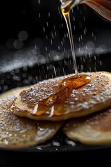 A person pours syrup onto a stack of pancakes