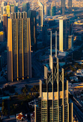 Obraz premium An aerial view of the Dubai skyline, showcasing several modern towers against a golden sunset. The image captures the citys unique architecture and vibrant energy.