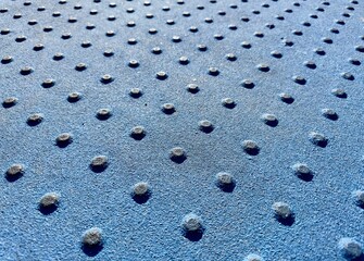 A detectable warning surface for disabled pedestrians provides tactile cues for safe navigation, enhancing accessibility and safety in public spaces with its distinct, raised texture.
