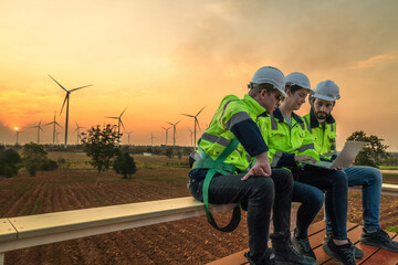 Team Engineers men and woman checking and inspecting on construction with sunset sky. people operation. Wind turbine for electrical of clean energy and environment. Industrial of sustainable. © ultramansk