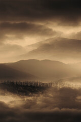 dramatic mountain landscape with fog in sunset light