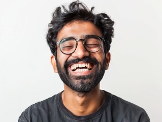 Obraz premium Portrait of a happy indian man in his 30s laughing isolated on white background