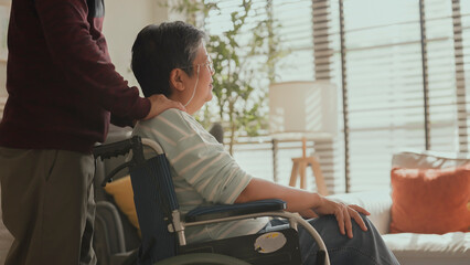 asian family spend time together encourage takecare.Husband embrace his wife in wheelchair with...