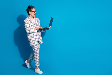Photo of lovely successful nice woman wear white trendy clothes walk empty space isolated on blue color background