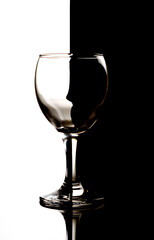 Wine glass silhouette on a half white and half black background. Can represent balance, imperfection, yin yang, contrasts.