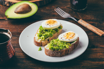 Two avocado toasts with boiled egg