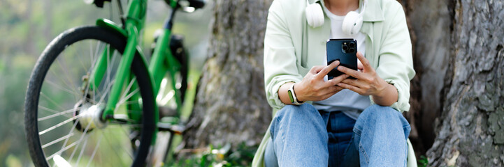Attractive adult asian woman using smart phone at outdoor park. .