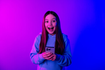 Photo of excited pretty little lady dressed hoodie chatting instagram twitter telegram facebook isolated neon purple color background
