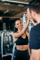 Fototapeta premium Focus on the fit girl giving a high-five to her male partner.