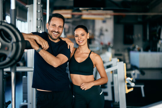 A fit couple posing for the camera at the gym.