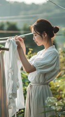 Fototapeta premium A woman hangs clothes on a clothesline in a garden