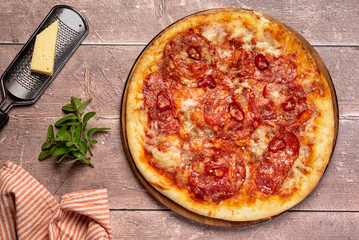 Food photography of pizza with spicy salami, red chilli, pepperoni, mozzarella, cheese; pork, meat; tomato sauce; oregano;  background; meal; food