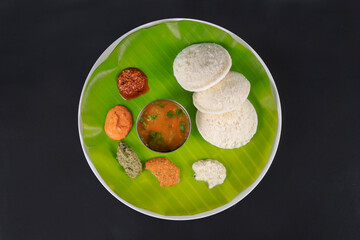 South indian breakfast food idli with sambar and chutney on banana leaf. Isolated image