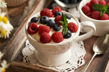 Cottage cheese blended with flax seed oil in a bowl, with fresh raspberries and blueberries
