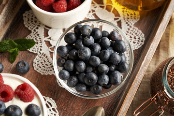 A bowl of blueberries with cottage cheese, flax seed oil and raspberries