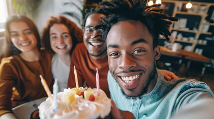 Fototapeta premium A joyful group of four friends celebrating a birthday with a cake and candles.