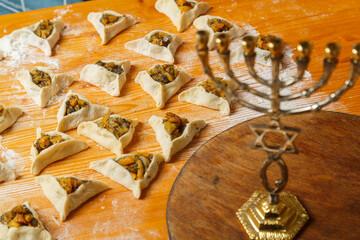 Sweet gomentashi cookies on the table in flour next to dried fruits