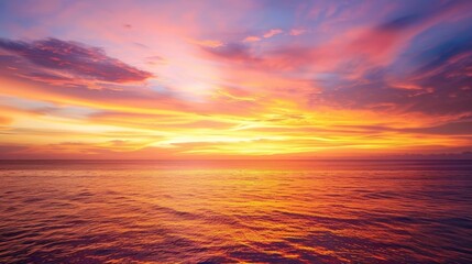 Obraz premium A tropical sunset over a calm ocean, with the sky painted in hues of orange, pink, and purple, embodying natural beauty