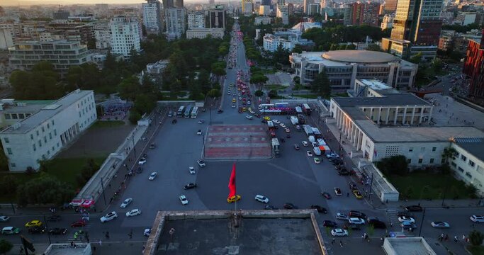 Aerial view of Mother Theresa Square in Tirane Albania at sunset time showing the Albanian Flag at the top of University Building. 