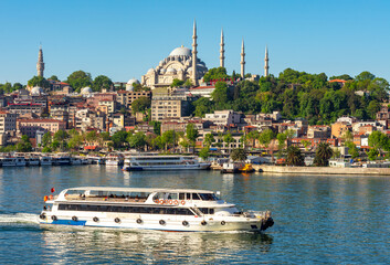 Istanbul cityscape with Suleymaniye mosque and cruise boat in Golden Horn bay, Turkey
