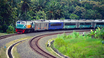 View of a passenger train moving in a rural or hilly area